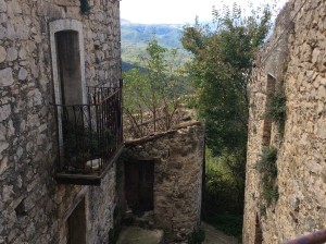 Break between houses along with the stairway down, with a view out into the western valley