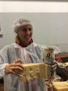 Alice holds up both a triangle of cheese and two packages of what is called the core. The wheels are cut with a wire to make two wheels and then the centers are cut out and sold separately. Cores are the best and but cutting the wheels that way, it is also easier to cut the pie shapes without crumbling