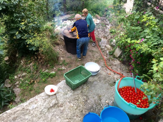 And on goes the old, wooden cover to help the tomatoes cook.